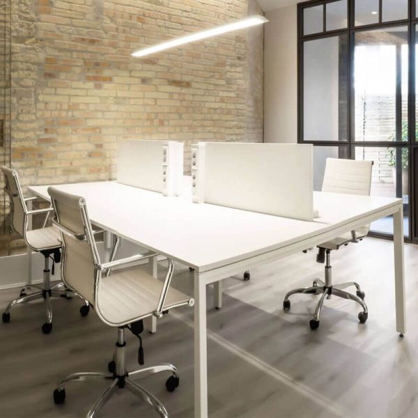 Lámpara de techo blanca Slimgot de Arkoslight encendida sobre una mesa de oficina | LeónLeds.com