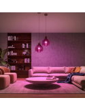 Lâmpada inteligente Philips Hue White e Color Ambiance A60 E27 1100lm detalhe de luz rosa em uma sala de estar