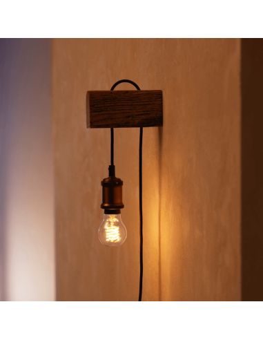 Bombilla inteligente Philips HueWhite 7W 2100K 550lm A60 E27 colocada en un aplique de pared