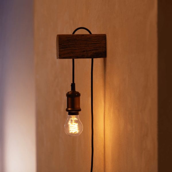 Bombilla inteligente Philips HueWhite 7W 2100K 550lm A60 E27 colocada en un aplique de pared