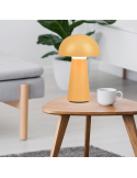 Lámpara de sobremesa Lennon amarillo encima de una mesa encendida| LeonLeds