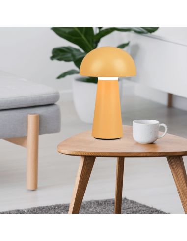 Lámpara de sobremesa Lennon amarillo encima de una mesa encendida| LeonLeds