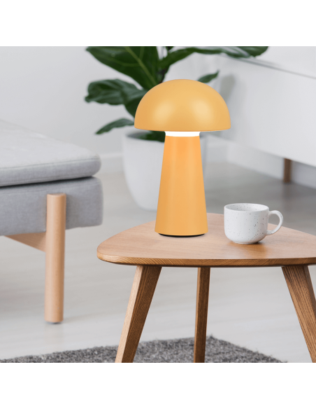 Lámpara de sobremesa Lennon amarillo encima de una mesa encendida| LeonLeds
