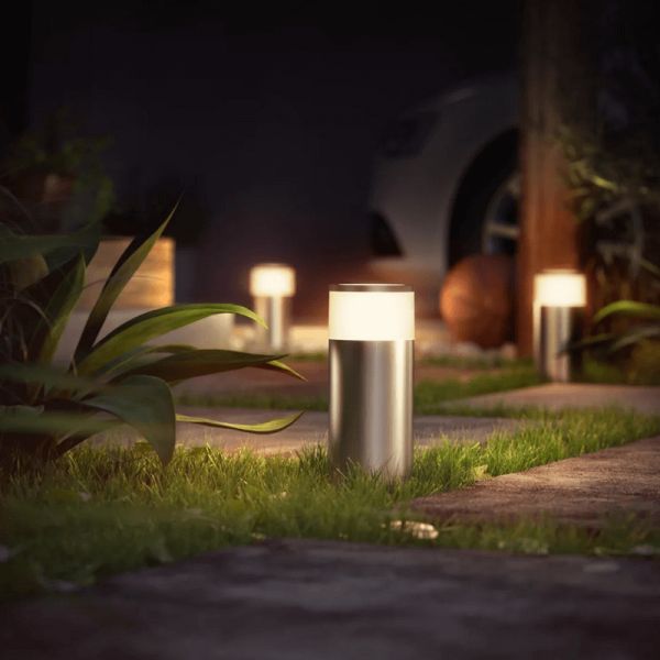 Baliza exterior LED inteligente Calla cromo mate 8W en un jardín encendida