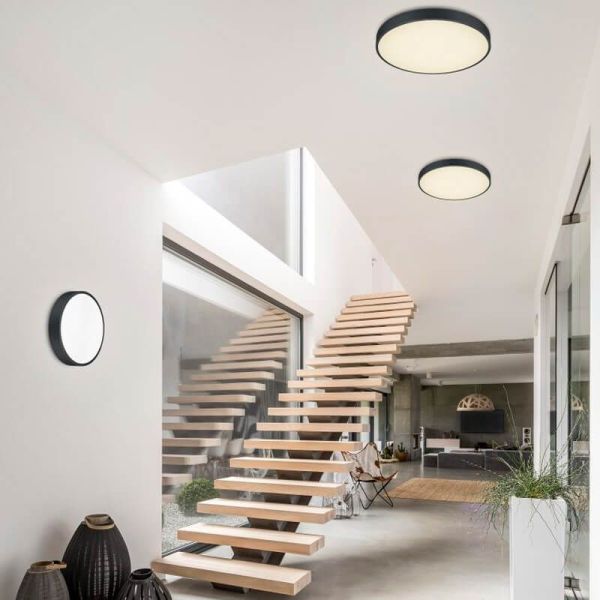 Plafón LED redondo Waco negro mediano en un pasillo