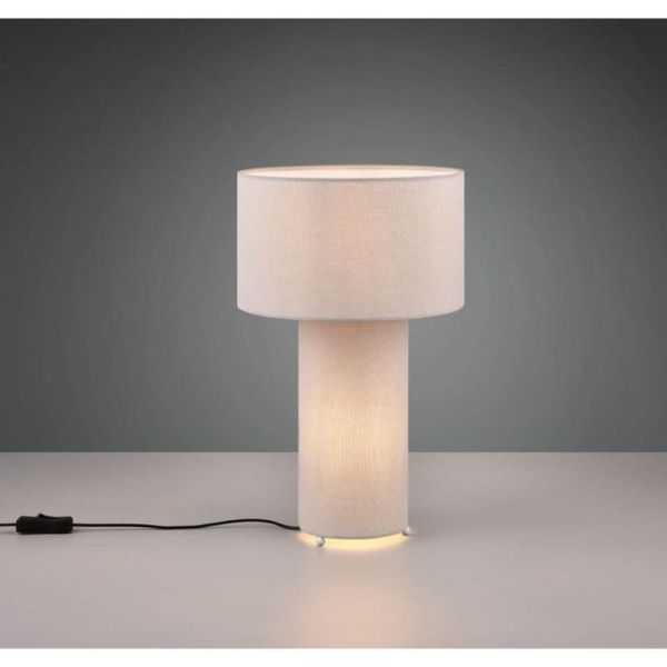 Candeeiro de mesa têxtil cinzento BALE sobre uma mesa iluminada